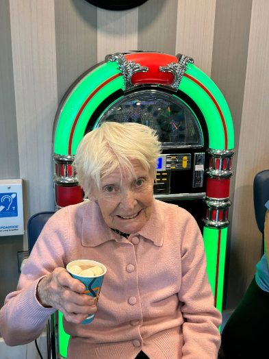 Resident enjoying a hot chocolate during Pyjama & Teddy Bear Day